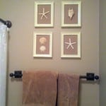 A bathroom with shells in four picture frames as decor
