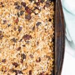 homemade granola with raisins and dried cranberries on baking sheet