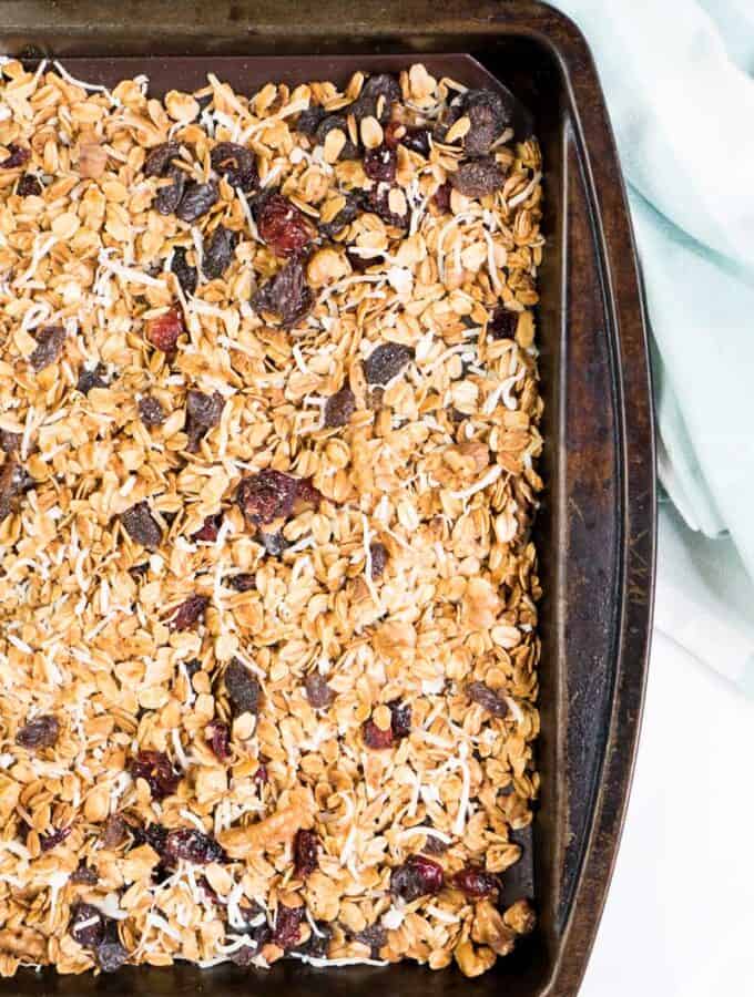 best homemade granola with raisins and dried cranberries on baking sheet