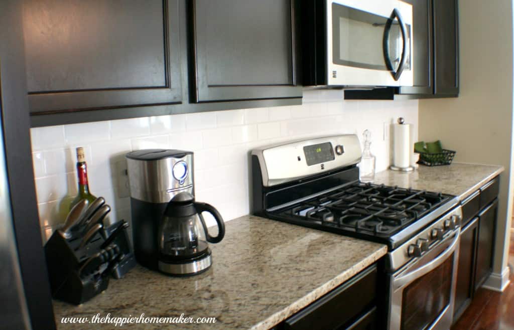 A modern kitchen with dark cabinets and a gas range