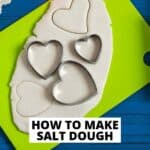 text reading how to make salt dough with green cutting board with salt dough rolled out and three heart shaped cookie cutters on it.