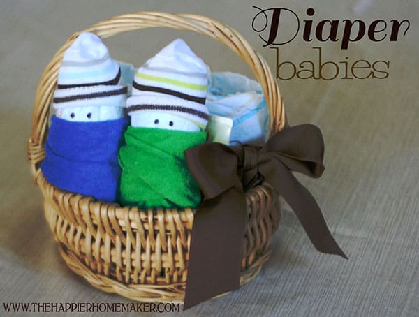 A close up of diaper babies in a wicker basket with a brown bow