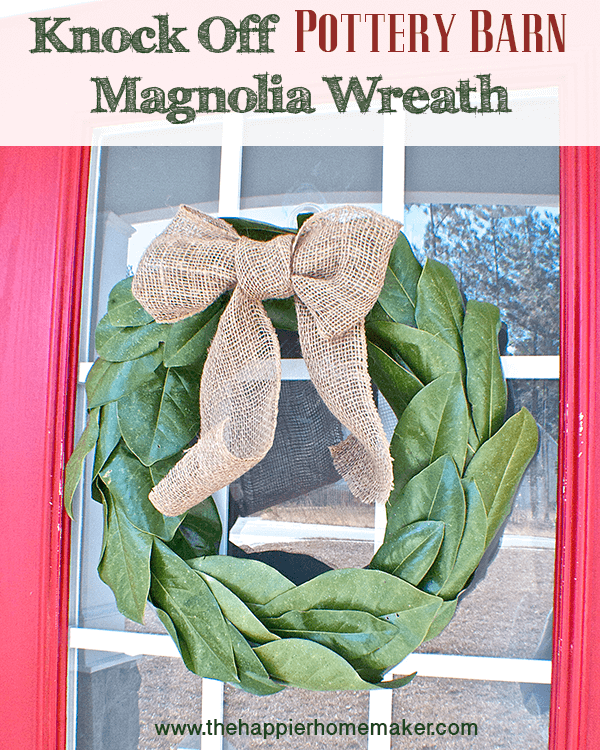 A close up of magnolia leaves decorated as a wreath with a burlap bow