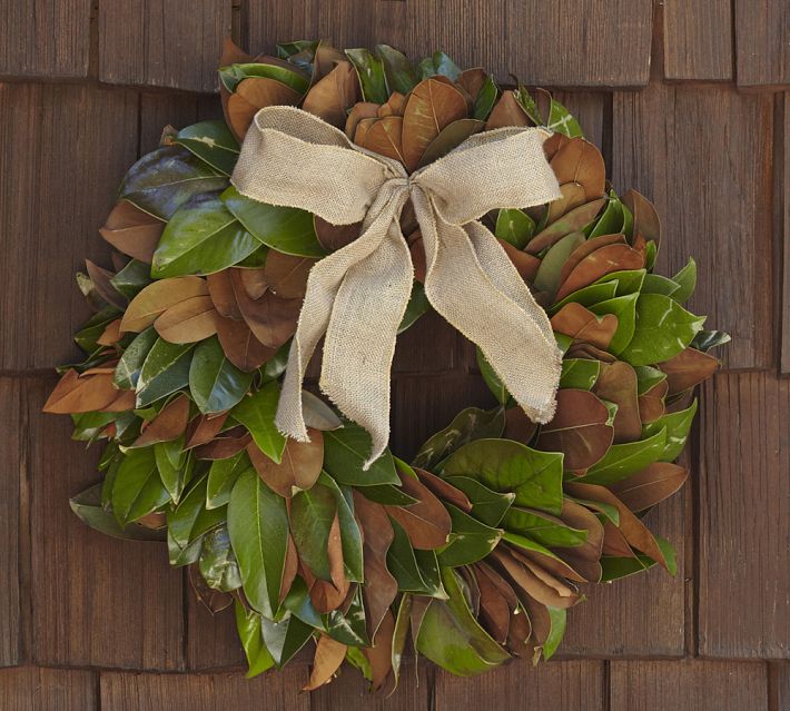 A close up of a Pottery Barn magnolia wreath with brown bow