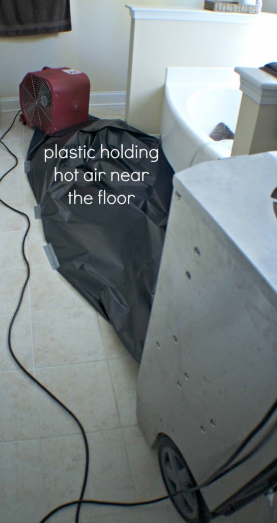 Black plastic holding hot air near the floor to dry the laminate flooring