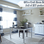 A finished office or craft room complete with a table, storage unit and decorative shelves