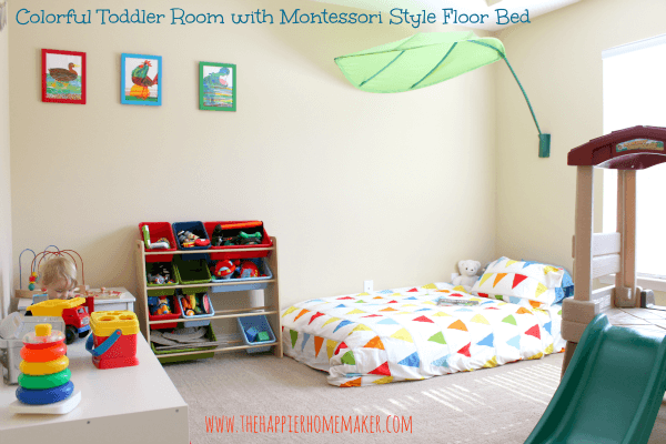 A toddler nursery with a bed with a green fabric leaf over it and storage units 