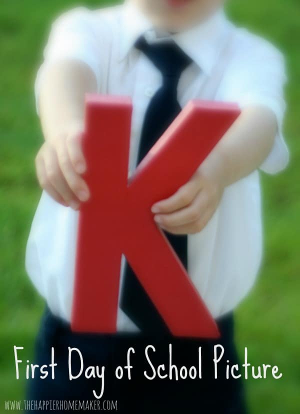 A child holding the letter "K" for the first day of school 