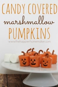 Candy covered marshmallows covered made to look like pumpkins with pieces of pretzel as a pumpkin stem