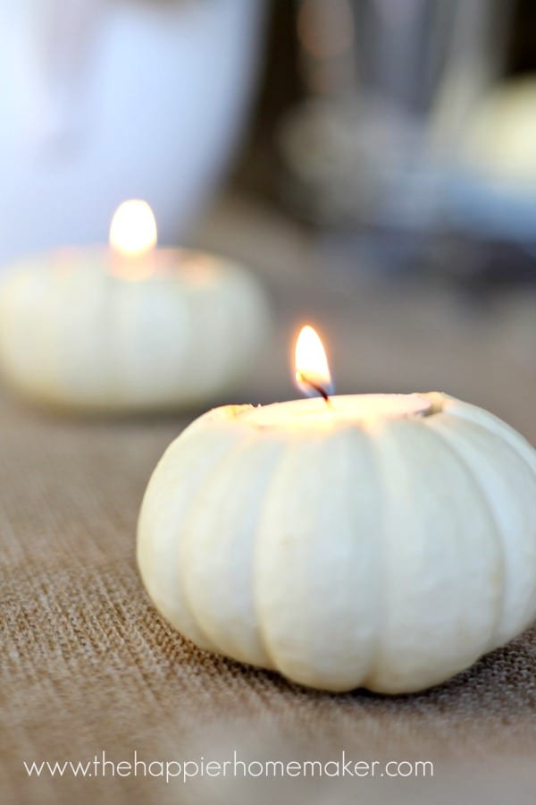 A close up of a white pumpkin with a small candle inside