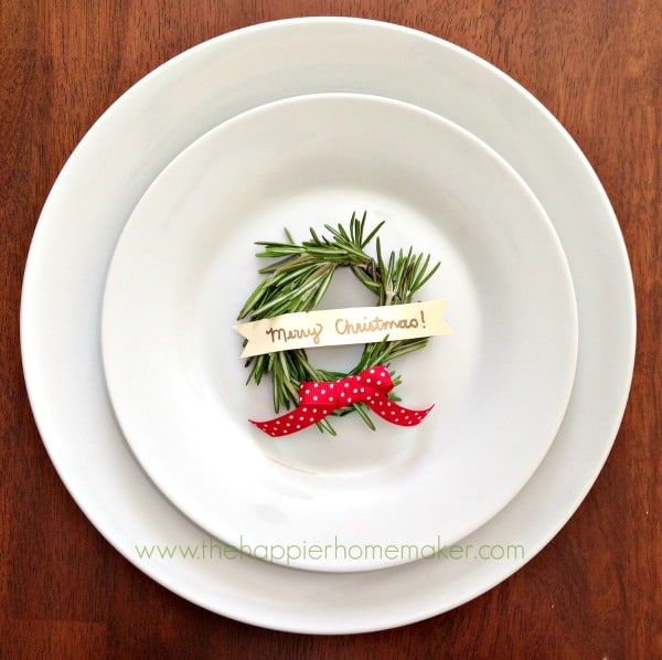 A white bowl and plate with a rosemary Christmas wreath place card