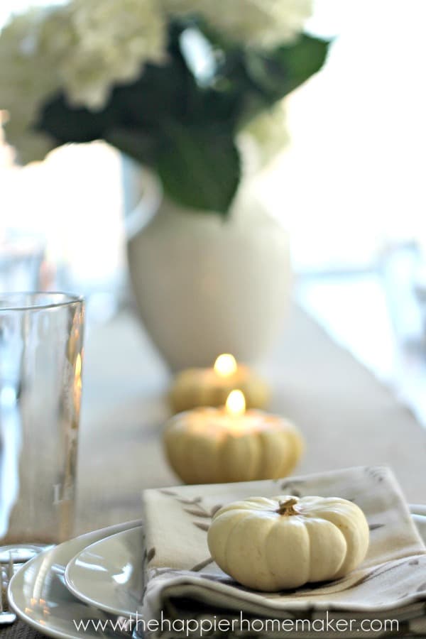 A close up of pumpkins hold tea candles for Thanksgiving dinner