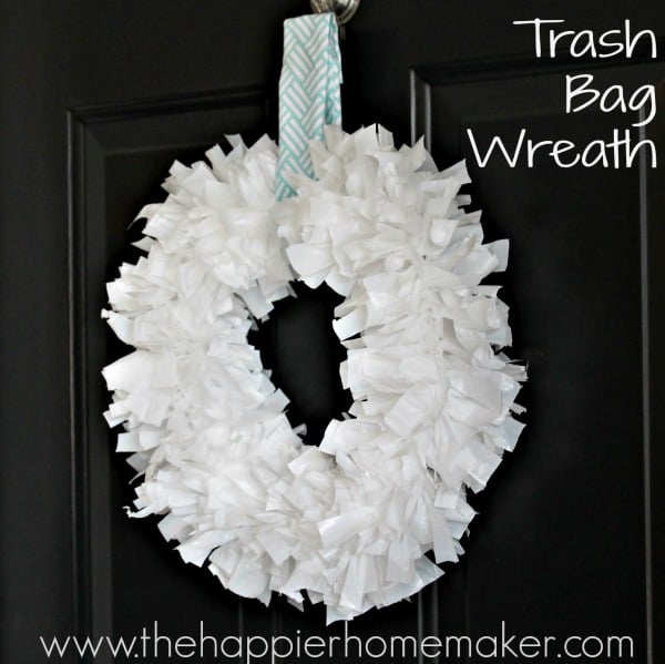 A white DIY trash bag wreath hanging on a dark door