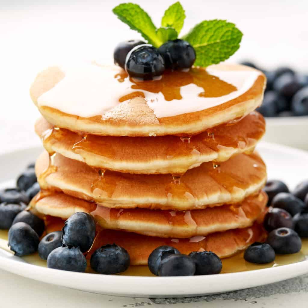 stack of pancakes with blueberries and mint sprig