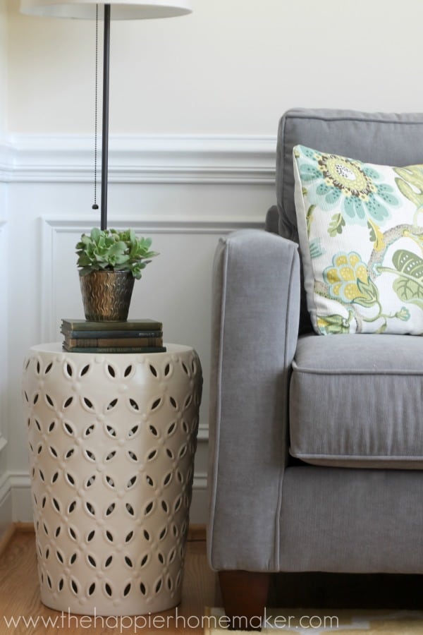 A white side table next to blue sofa