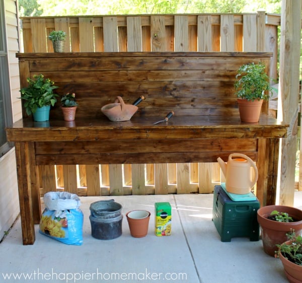 An upcycled headboard made into a potting bench