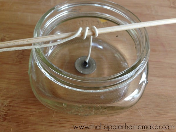 wick in empty mason jar with top wrapped around skewer balanced on the top of the jar