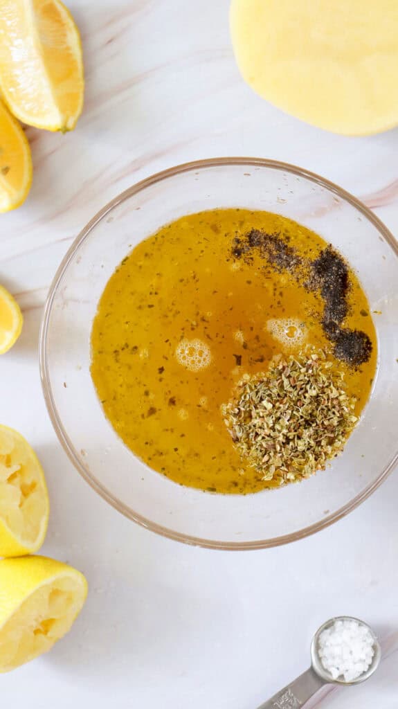 Greek lemon potatoes marinade in glass bowl