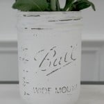 A distressed painted Mason jar used as a planter