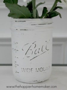 A distressed painted Mason jar used as a planter