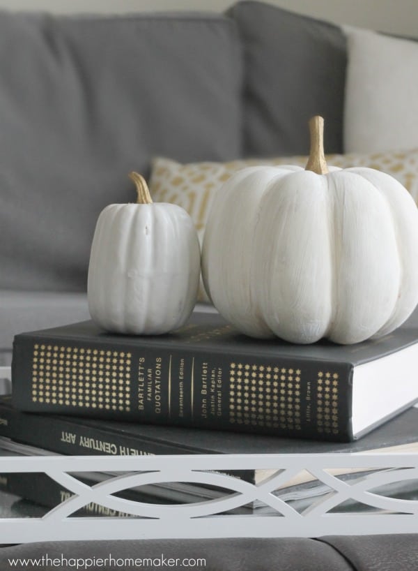 Two fake white pumpkins sitting on a book