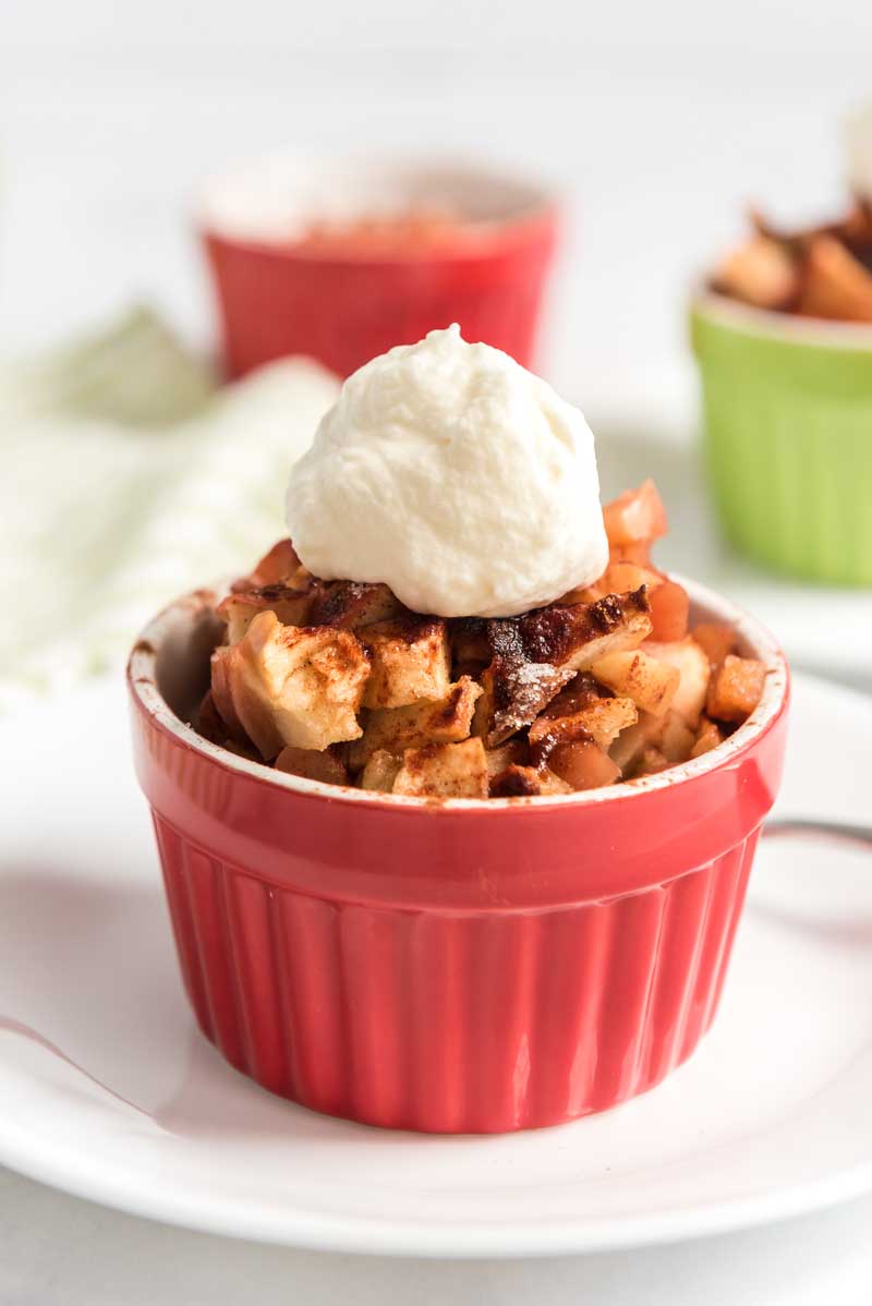 crustless apple pie in red ramekin topped with whipped cream