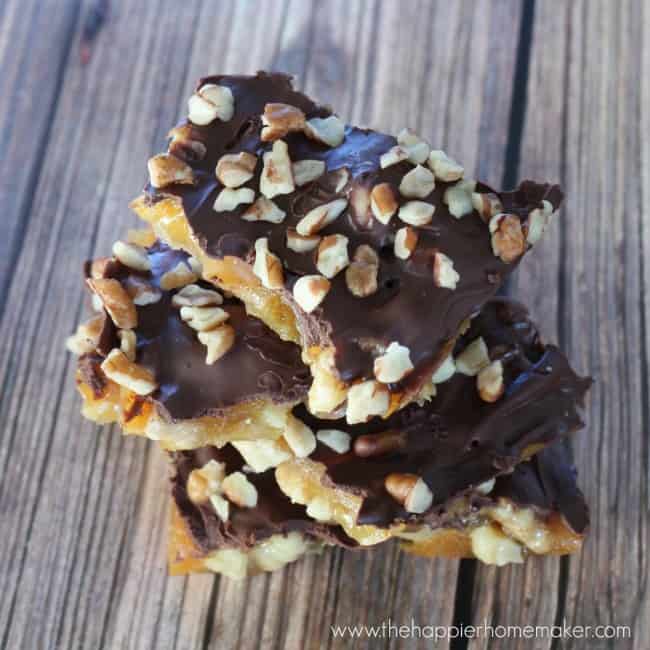 A close up of chocolate toffee stacked on top of each other topped with nuts