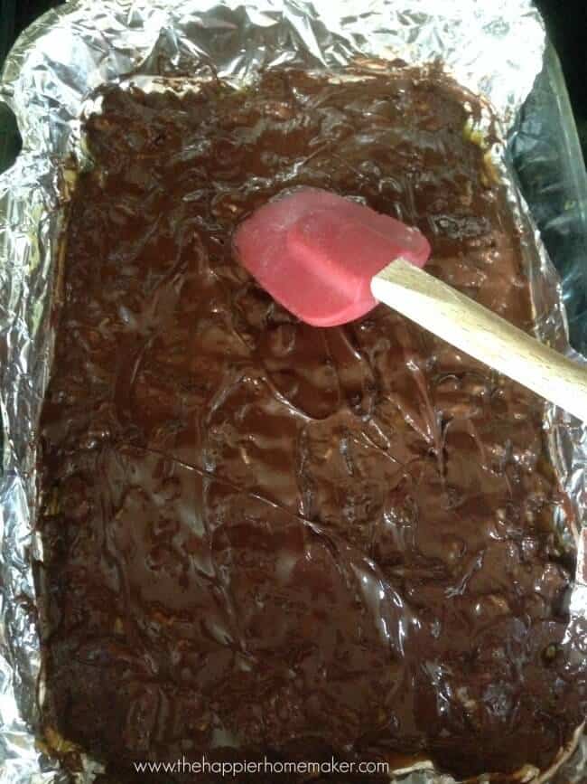 spreading chocolate on toffee with rubber spatula