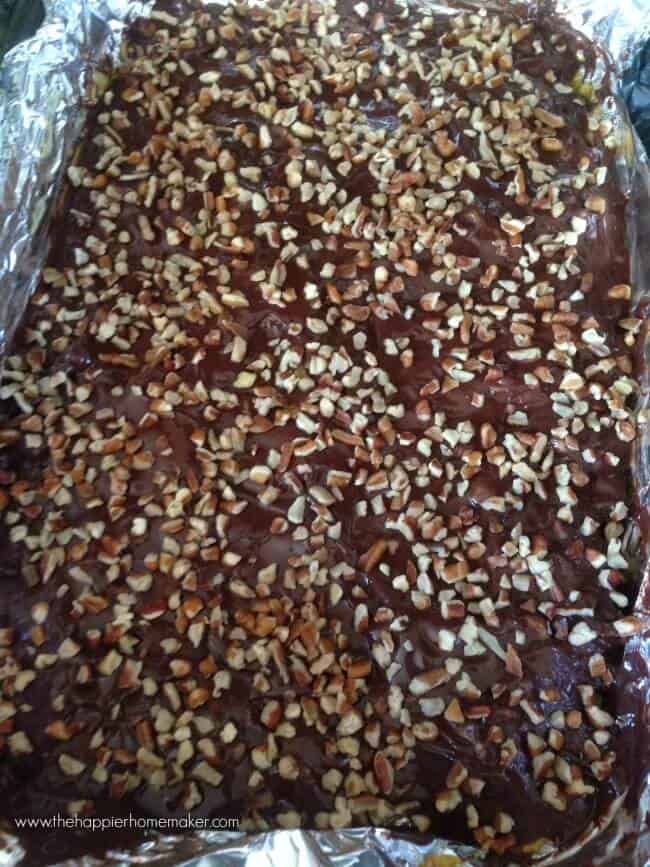 toffee topped with chopped nuts on foil lined baking sheet