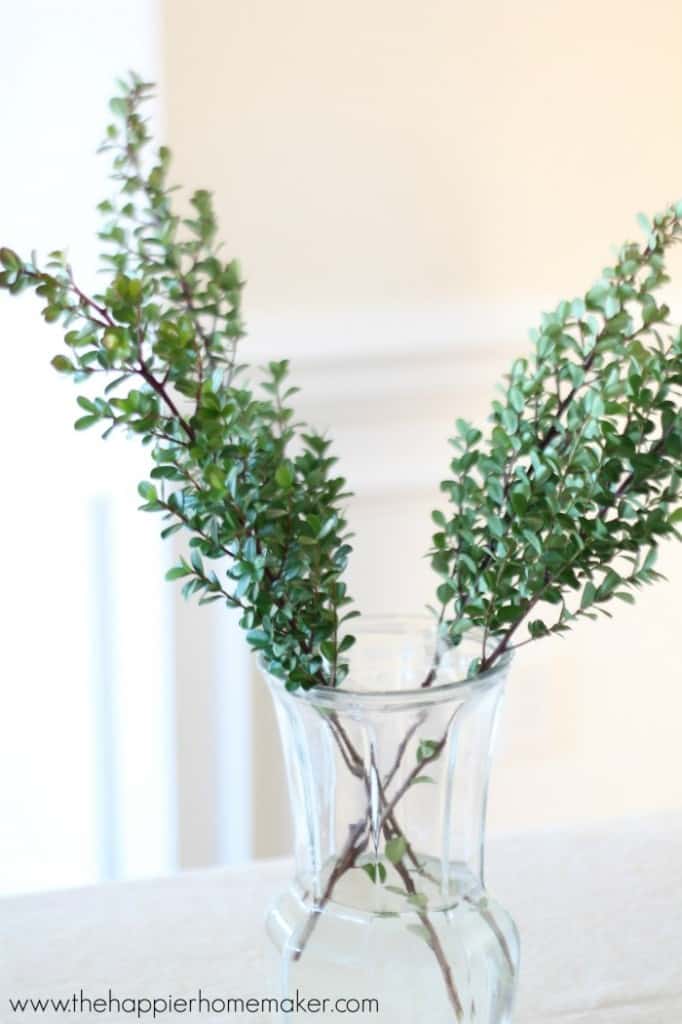 adding greenery to vase for flower arrangement