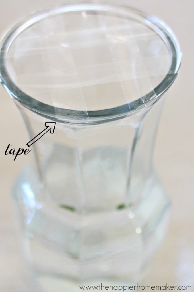 A glass vase with scotch tape making a grid over the top of the vase