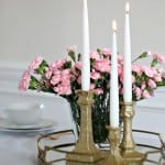 Three no shed glitter candlesticks in front of flowers on a white table