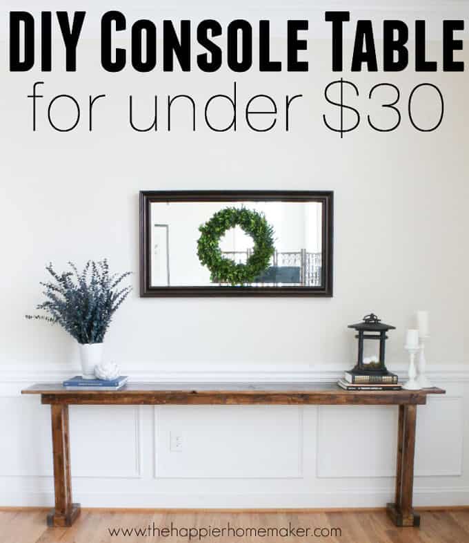 A DIY console table with greenery, lantern and candlesticks on it