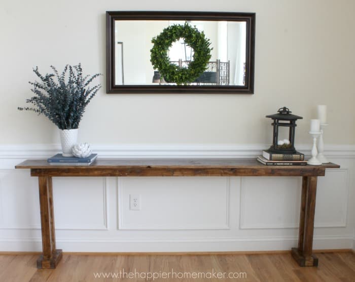 A DIY console table with greenery and a lantern on it