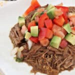 shredded beef on plate with pico de gallo and avocado