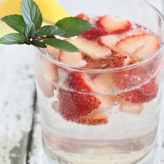 A close up of skinny strawberry fizz cocktail with fresh strawberries