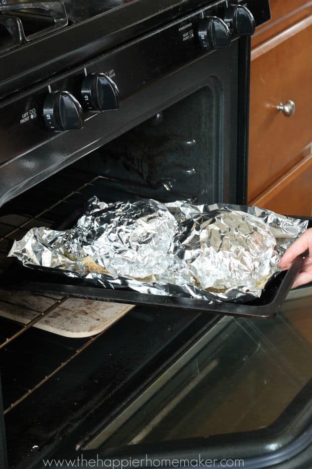 An in-process picture of someone making pesto cheesy pull apart bread by putting it in the oven