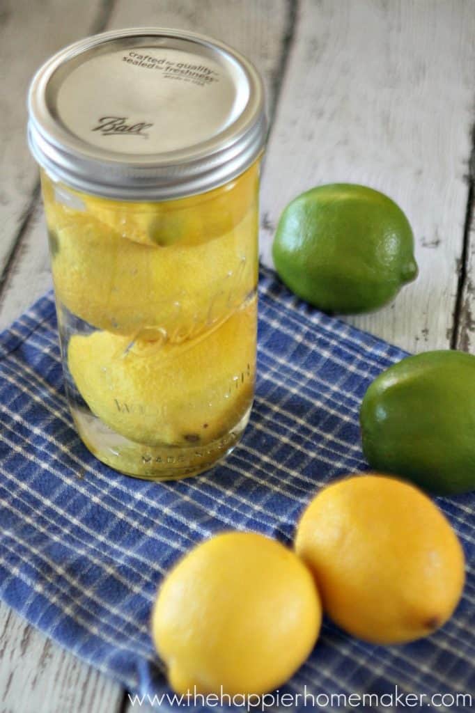 A mason jar with lemons in water showing how to make the fruit last longer
