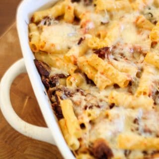A close up of cheesy bacon baked ziti in a white baking dish
