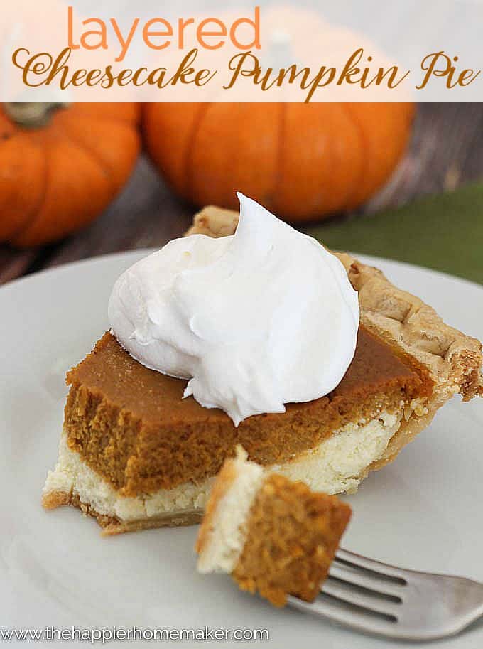 A piece of pumpkin pie cheesecake topped with whipped cream and two orange pumpkins in the background