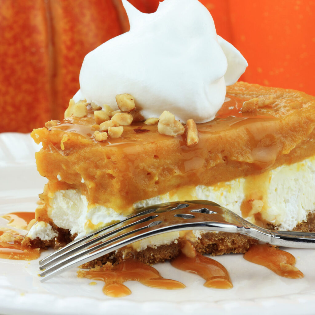 layered cheesecake and pumpkin pie with bite taken out