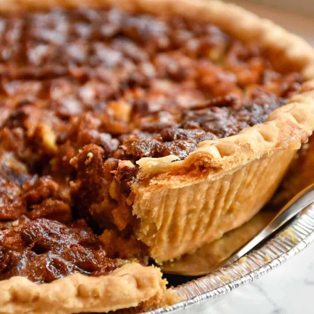 slice of pecan pie being lifted from dish