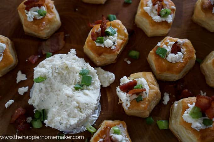 boursin and bacon stuffed puff pastries on wood cutting board