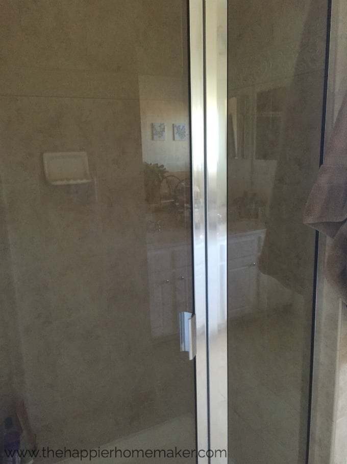 A glass shower door with water spots
