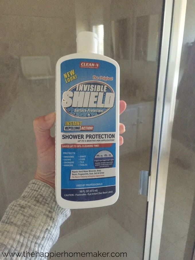 A close up of invisible shield cleaner in front of a glass shower door