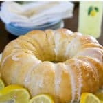 limoncello bundt cake on white cake stand with lemon garnish