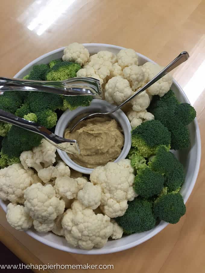 A plate of cauliflower and broccoli with hummus in the center