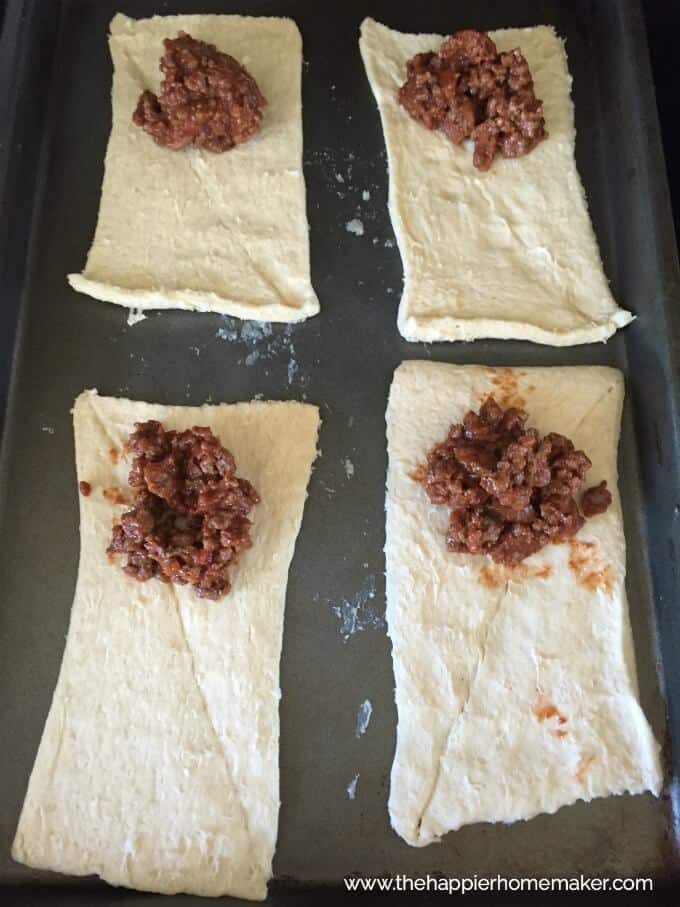 An in-process picture of preparing sloppy joe pockets with sloppy joe meat added to the dough
