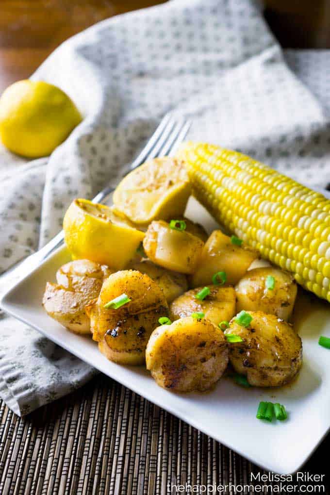 Seared scallops with corn on white plate