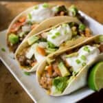 three oven baked soft tacos on white plate
